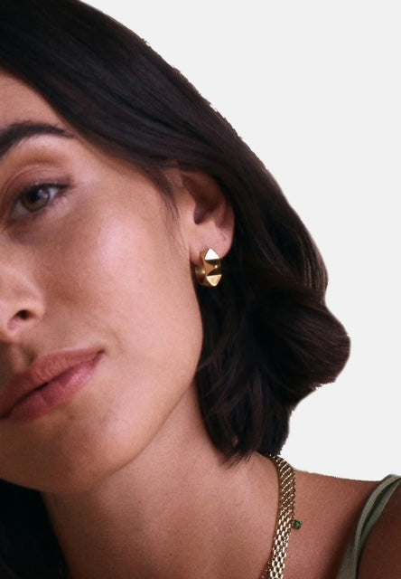 Edblad Peak Rivet Creole Earrings In Gold, styled and worn on a model
