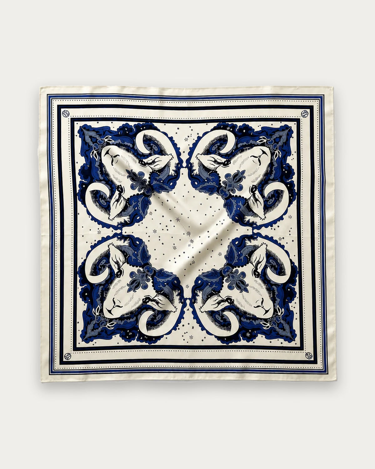 Zodiac Scarf Aries in Cream and Blue by Lescarf, 65x65 cm, laid flat in cream with four blue ram heads, stars and a blue striped border