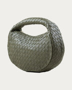ALEO Laluna Mini Woven Shoulder Bag in Olive, three-quarter view showing the woven handle, on soft stone background