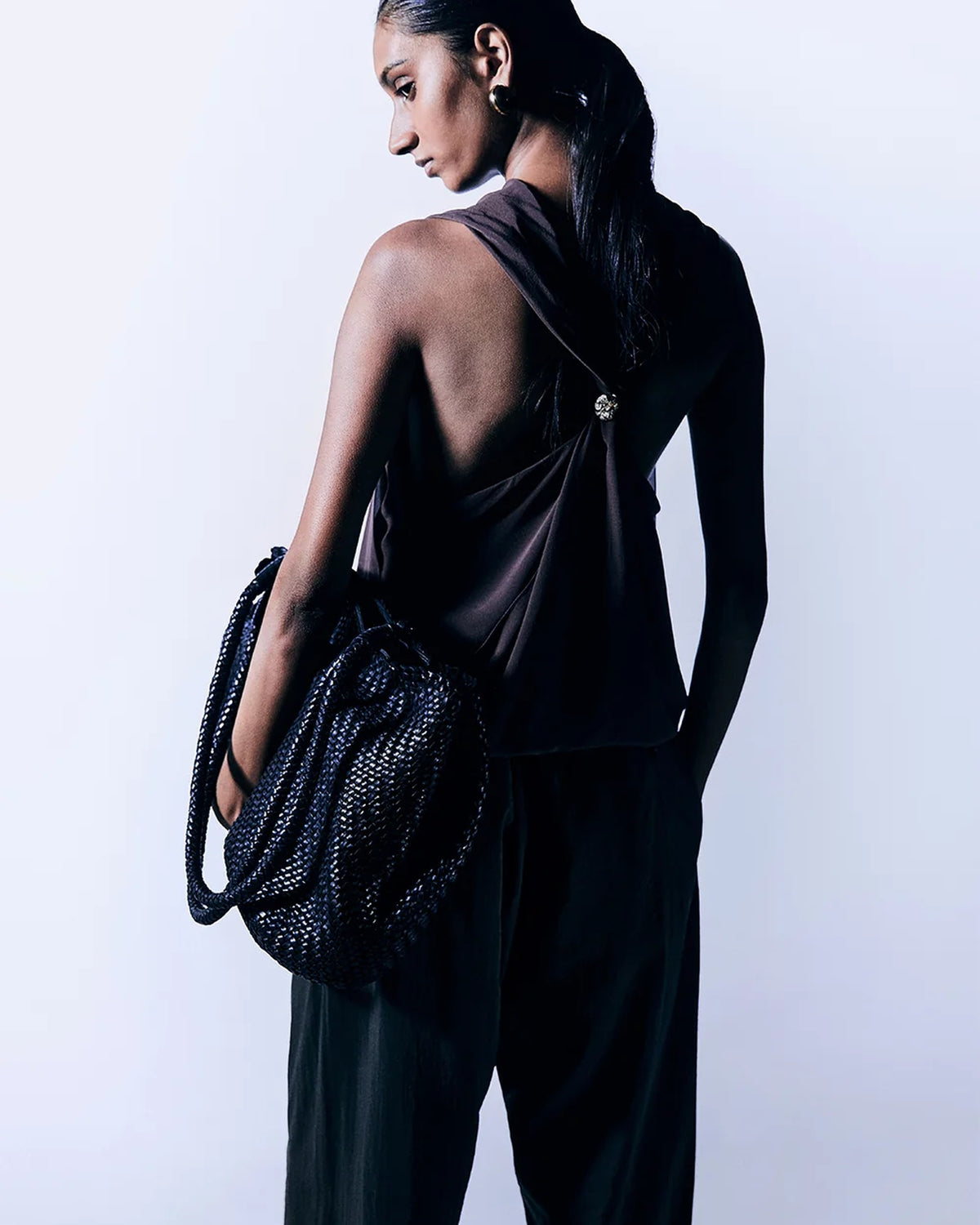 Model seen from behind carrying the ALEO Romy Woven Tote in Black on her arm