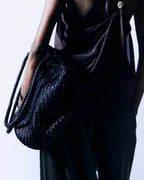 Close-up of the ALEO Romy Woven Tote in Black carried on the arm by a model