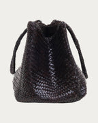 ALEO Romy Woven Tote in Crema, front view with braided handles falling to the sides, on soft stone background