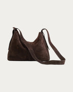 ALEO Shiloh Suede Shoulder Bag in Crema with the long crossbody strap laid out, on soft stone background