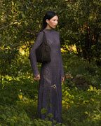 Model wearing the ALEO Shiloh Suede Shoulder Bag in Crema on her shoulder in a garden