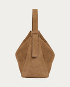 ALEO Shiloh Suede Shoulder Bag in Toffee, side view showing the buckled shoulder strap, on soft stone background