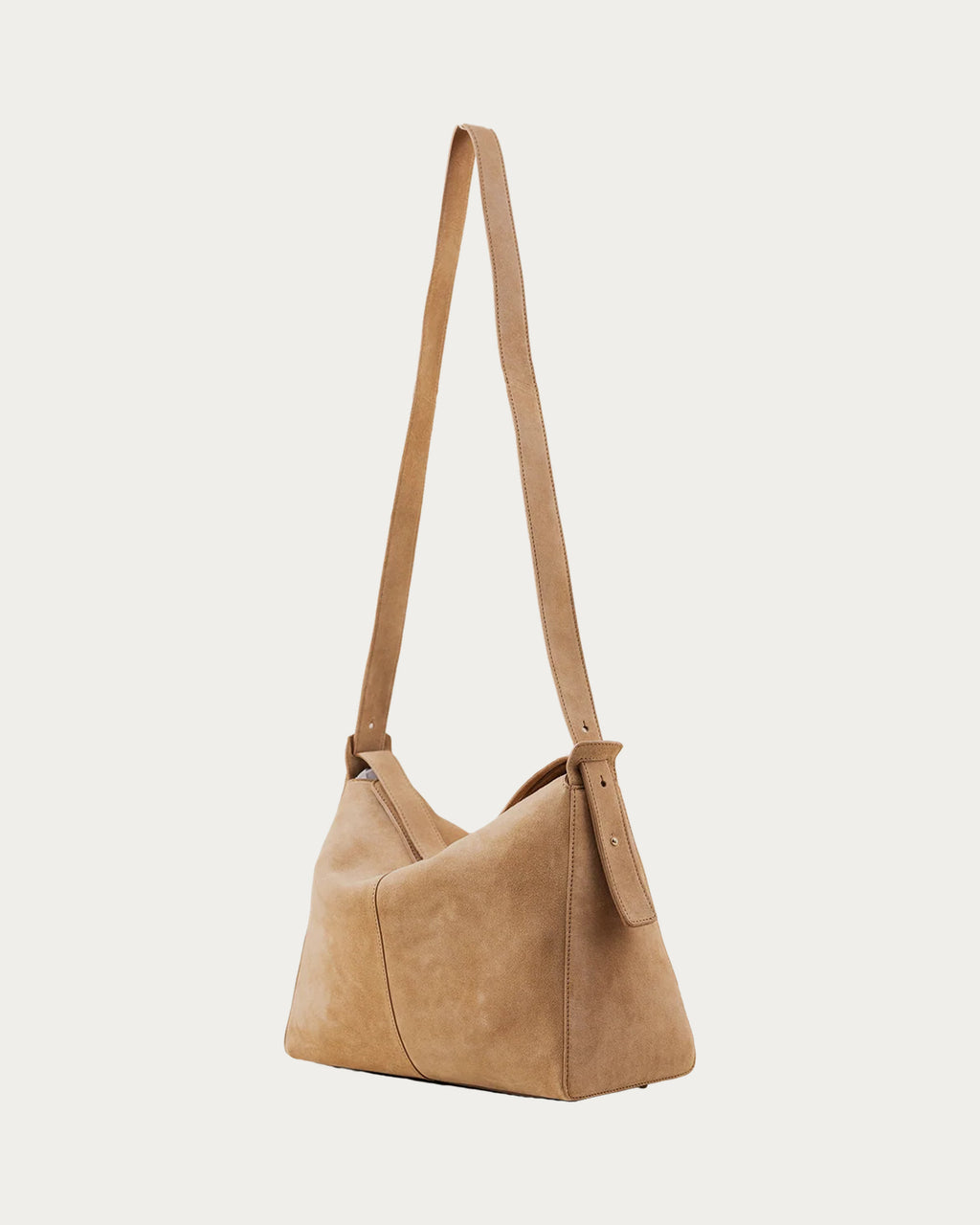 ALEO Shiloh Suede Shoulder Bag in Toffee, three-quarter view with the long cross-body strap, on soft stone background