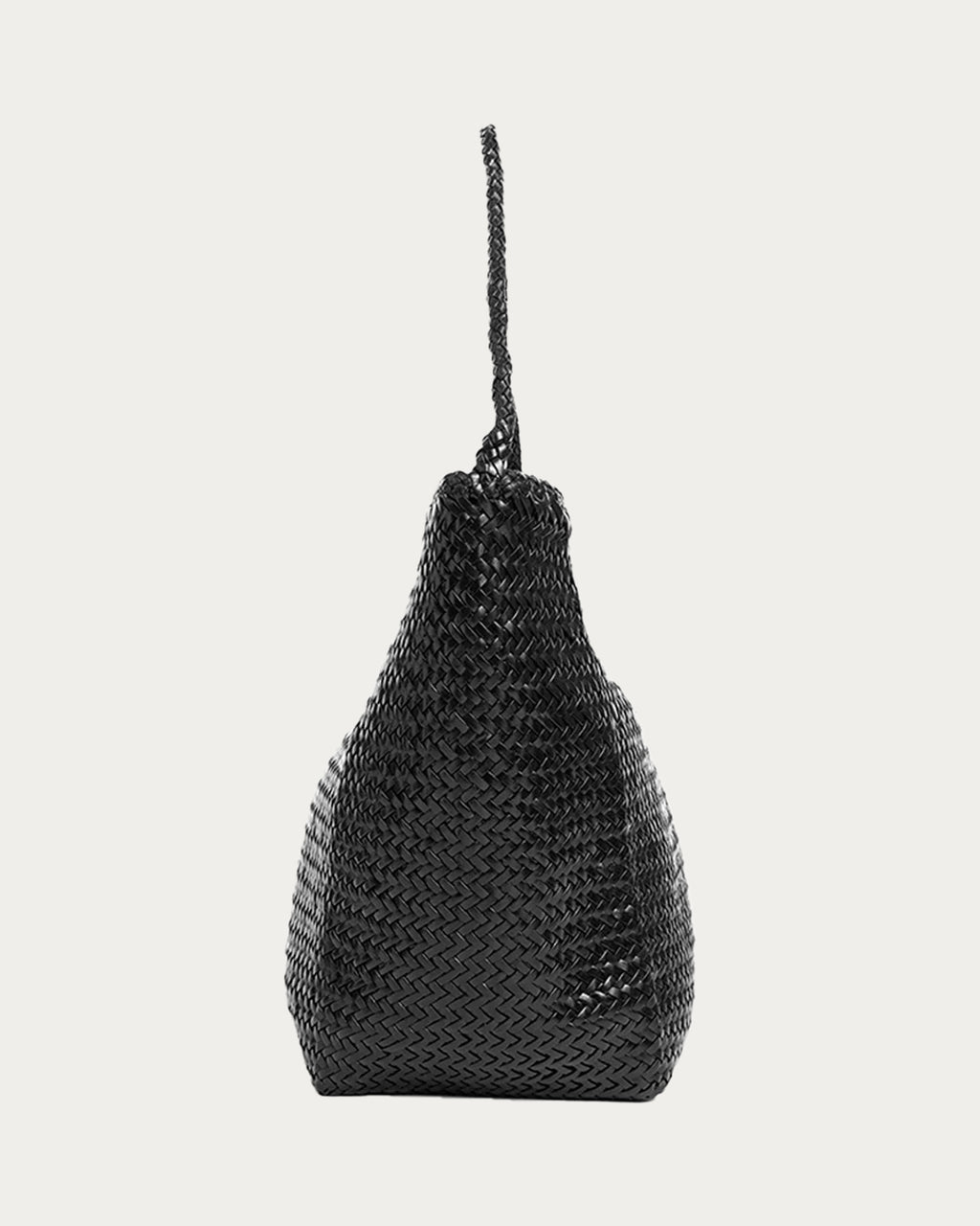 ALEO Toka Woven Tote in Black, side profile showing the braided shoulder strap, on soft stone background