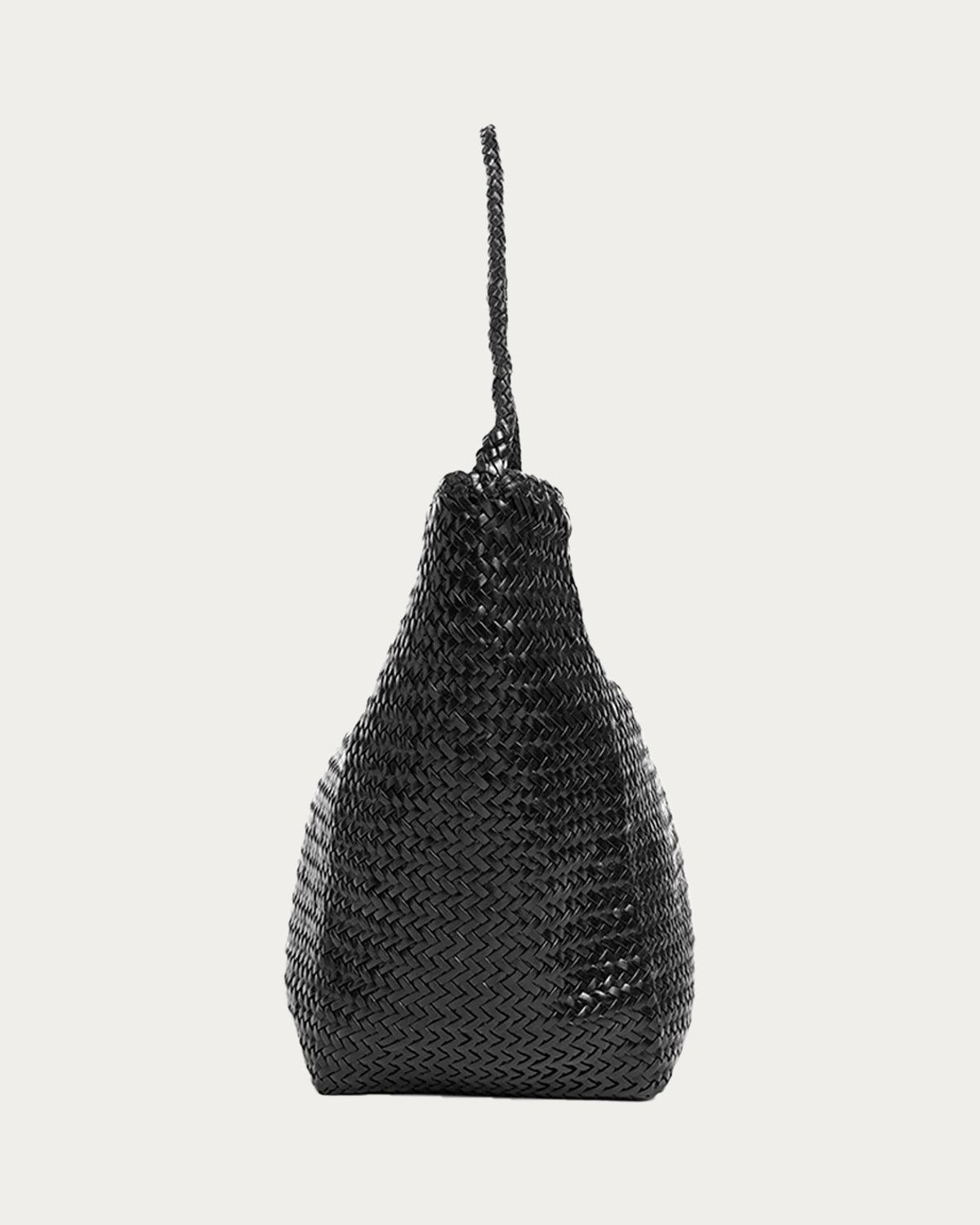 ALEO Toka Woven Tote in Black, side profile showing the braided shoulder strap, on soft stone background