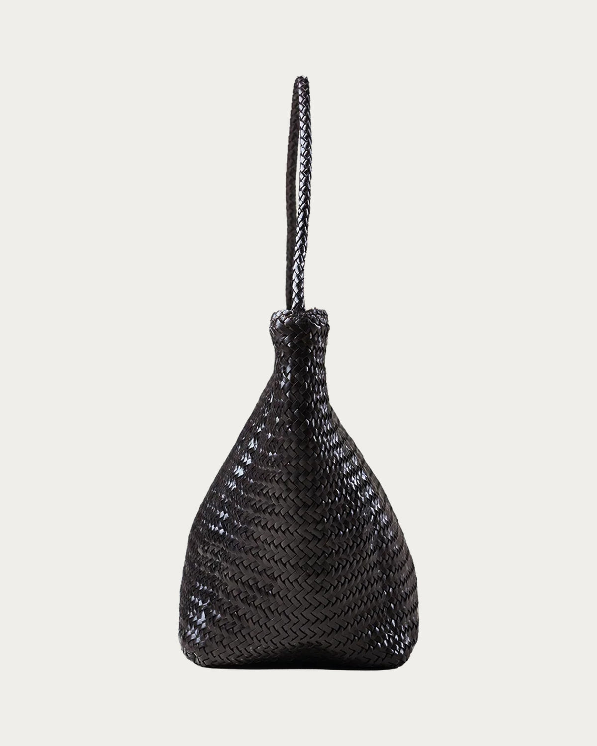 ALEO Toka Woven Tote in Crema, side profile showing the braided shoulder strap, on soft stone background