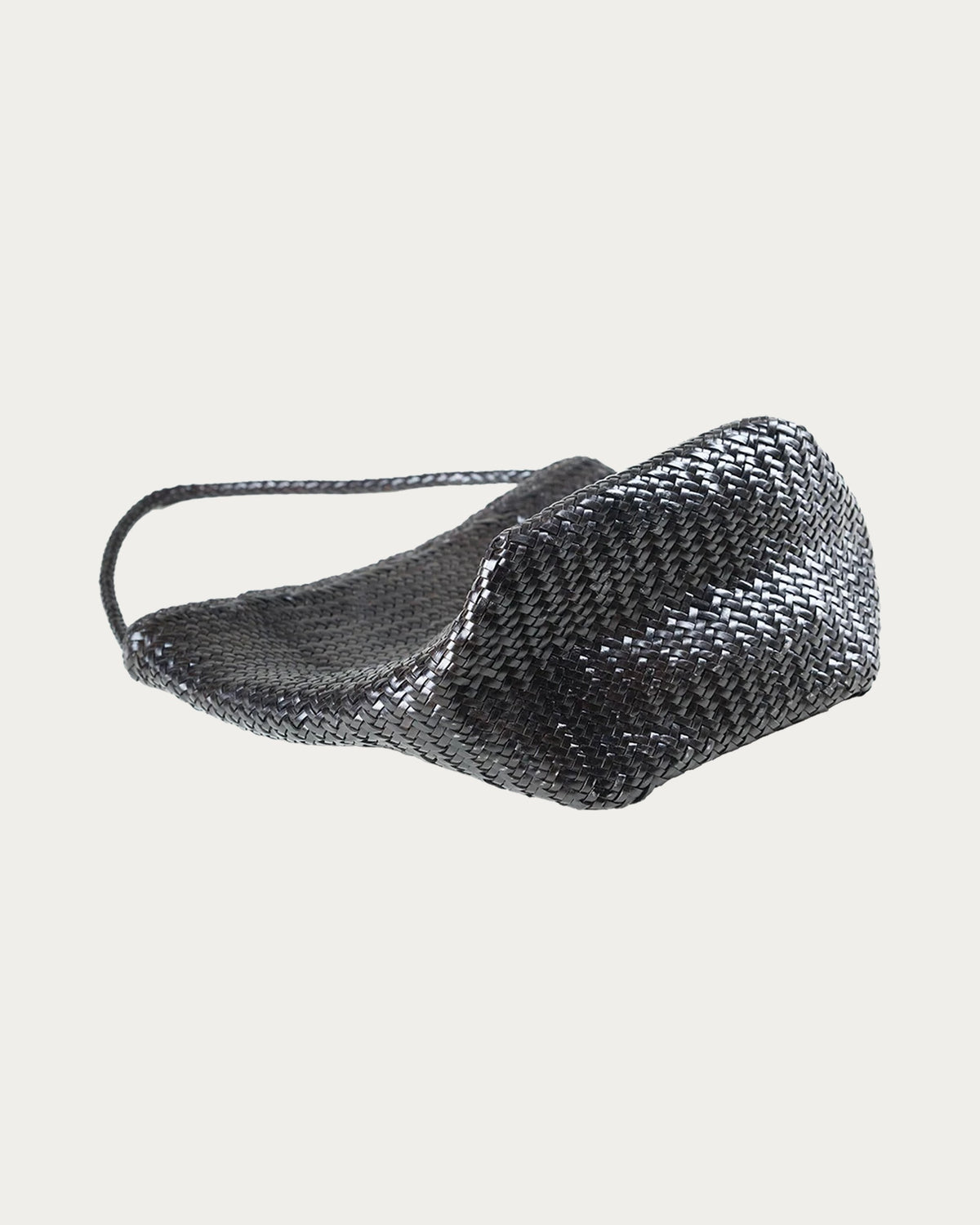 ALEO Toka Woven Tote in Crema, tilted view showing the handwoven leather body, on soft stone background