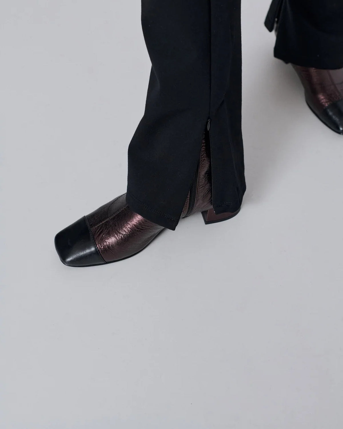 Close-up of model wearing Augusta chocolate metallic leather ankle boots