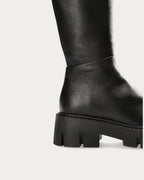 Close-up of the side logo and grooved platform sole on the Copenhagen Studios black leather knee high boot