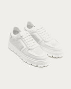 Pair of Copenhagen Studios white leather platform sneakers, three-quarter view with white laces