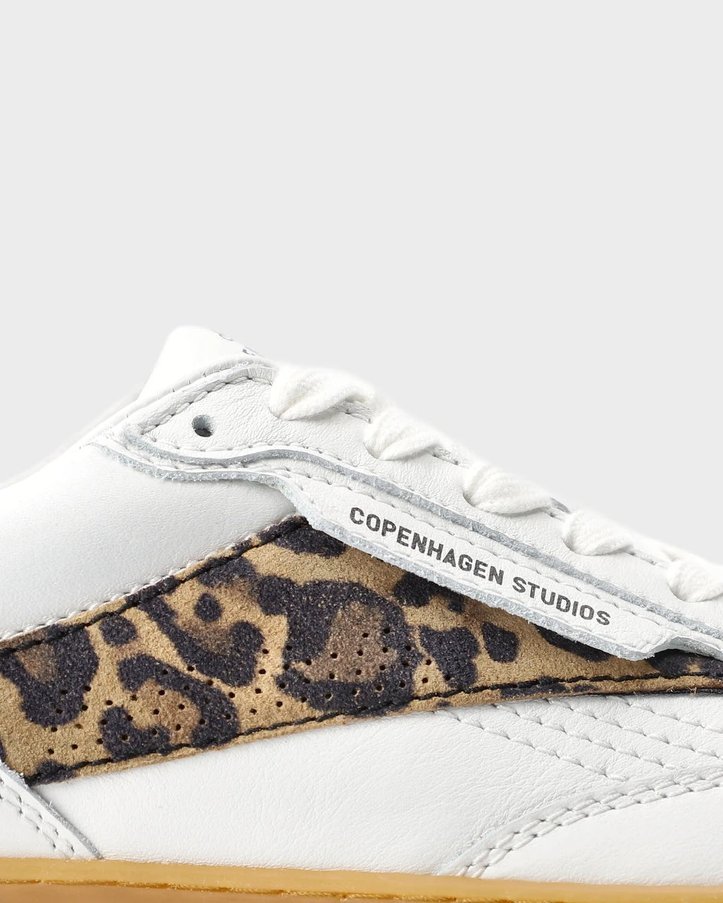 Close-up of the leopard suede panel and Copenhagen Studios logo flap on a white leather sneaker