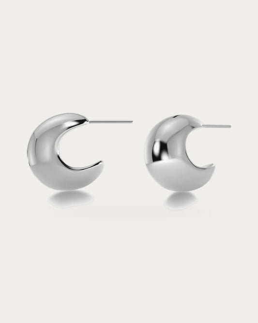 Edblad Bold Small Creole Earrings In Steel, a pair of small round polished steel creole earrings, product photo on a soft off-white background