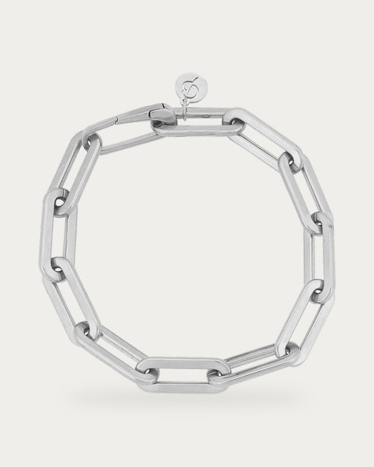 Edblad Ivy Maxi Bracelet In Steel, a polished steel bracelet made of large rectangular paperclip-style links with a logo charm, product photo on a soft off-white background