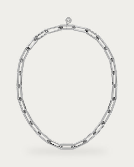 Edblad Ivy Maxi Necklace In Steel, a polished steel necklace made of large rectangular paperclip-style links with a logo charm, product photo on a soft off-white background