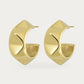 Edblad Peak Rivet Creole Earrings In Gold, a pair of wide gold creole earrings with soft square rivets, product photo on a soft off-white background