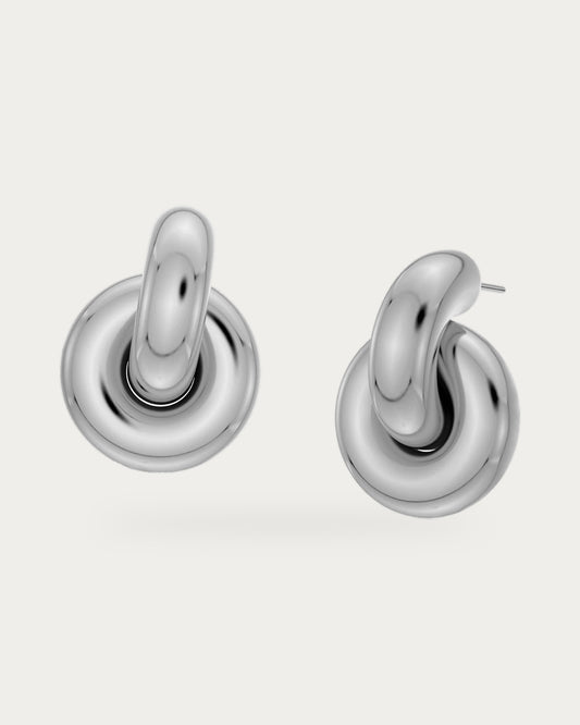 Edblad Redondo Large Stud Earrings In Steel, a pair of chunky rounded polished steel stud earrings, product photo on a soft off-white background