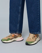 Model wearing Flower Mountain Kotetsu Woman Brown Green sneakers with wide-leg denim