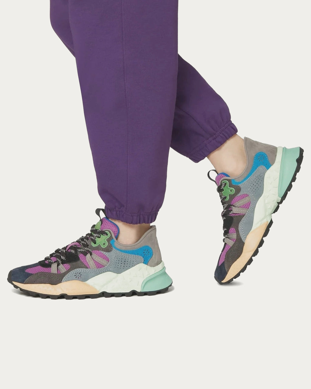 Model wearing Flower Mountain Tiger Hill Indigo sneakers with purple trousers