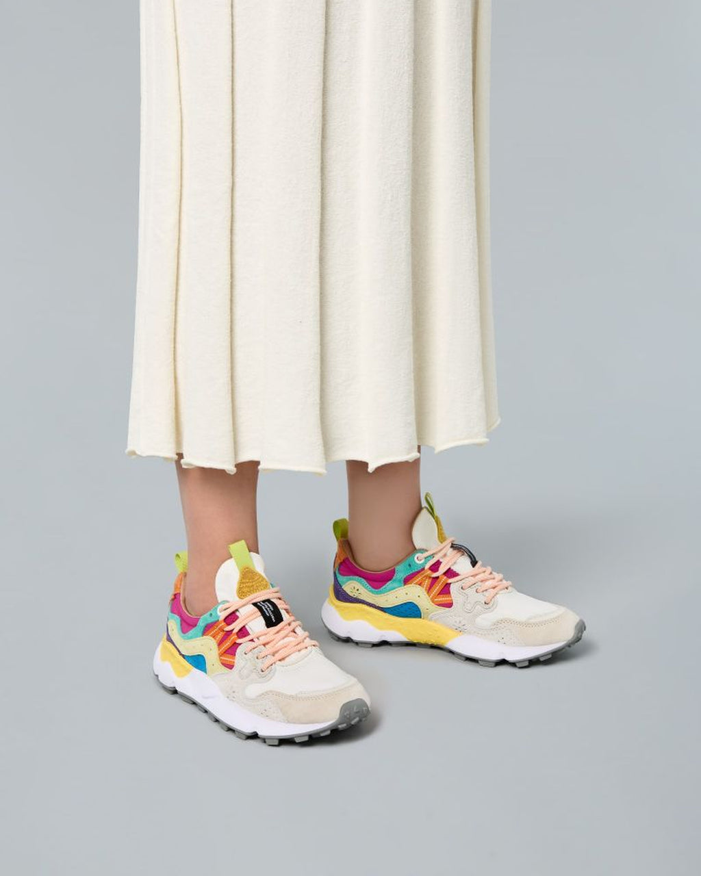 Model wearing Flower Mountain Yamano 3 Multi sneakers with a pleated skirt