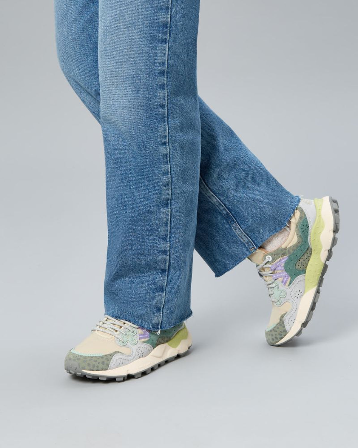 Model wearing Flower Mountain Yamano Green Animalier sneakers with straight-leg jeans