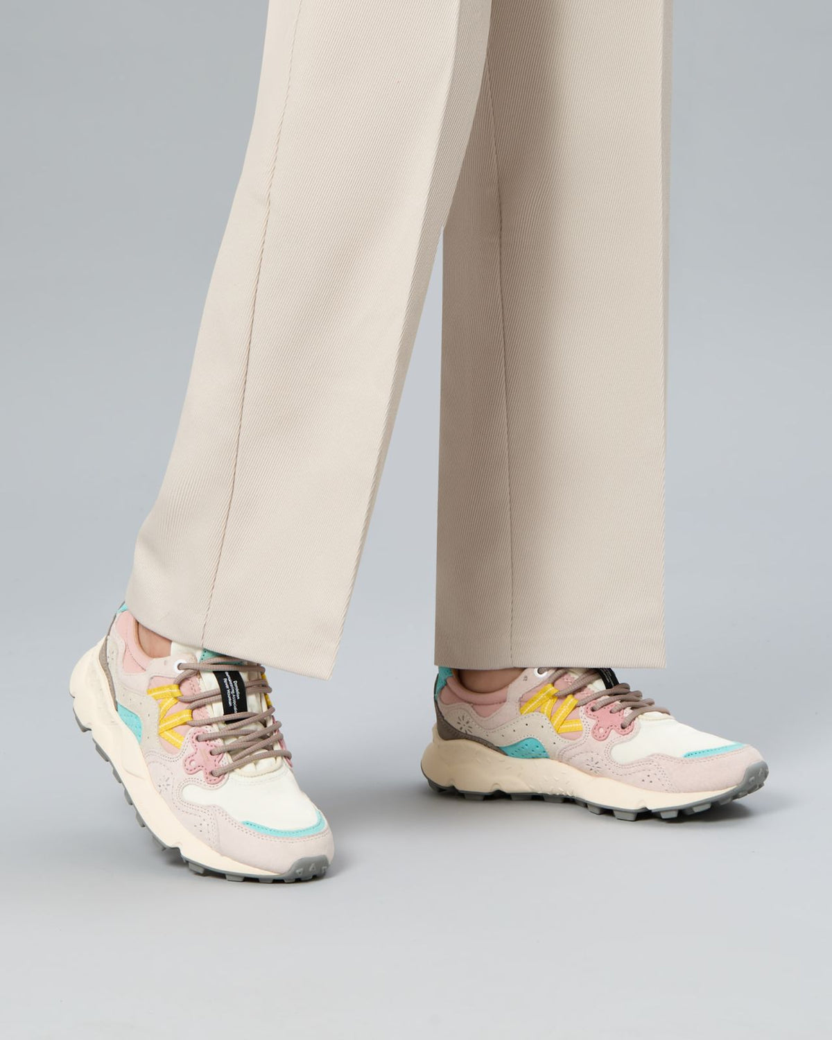Model wearing Flower Mountain Yamano Yello 1B54 sneakers with cream trousers