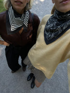 Lescarf cashmere paisley scarf in black with cream print, worn with a yellow knit