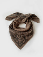 Lescarf cashmere paisley scarf in greige with black print, laid flat and loosely draped