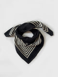 Lescarf cashmere striped scarf in black and cream, laid flat and loosely draped