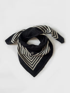 Lescarf cashmere striped scarf in black and cream, laid flat and loosely draped