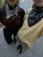 Lescarf cashmere striped scarf in black and cream, worn alongside the paisley scarf in black