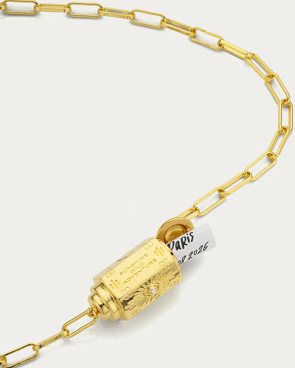 Close-up of the MYA—BAY Martinique Necklace barrel pendant with its hidden message scroll and engraved eye motif