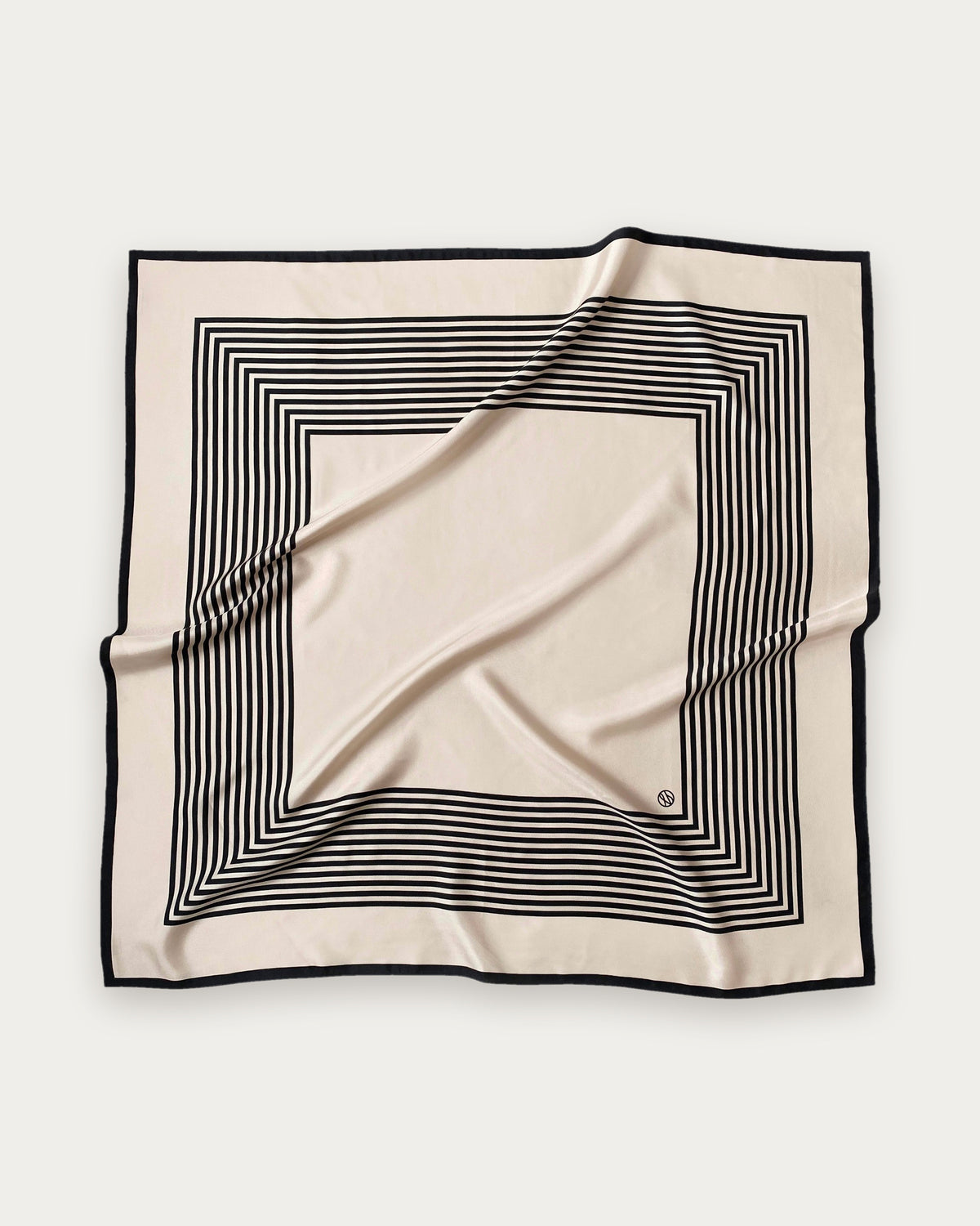 No.1 in Sand scarf by Lescarf, 90x90 cm, laid flat in sand with black concentric stripes and a black border