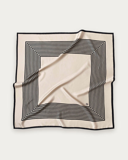 No.1 in Sand scarf by Lescarf, 90x90 cm, laid flat in sand with black concentric stripes and a black border