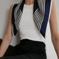Striped Scarf in Navy by Lescarf draped over the shoulders with a white ribbed top and black trousers