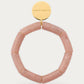 Flex Bracelet Blush Marble by Vanessa Baroni, blush marble tubular beads with gold discs and gold logo disc, front view on soft stone background