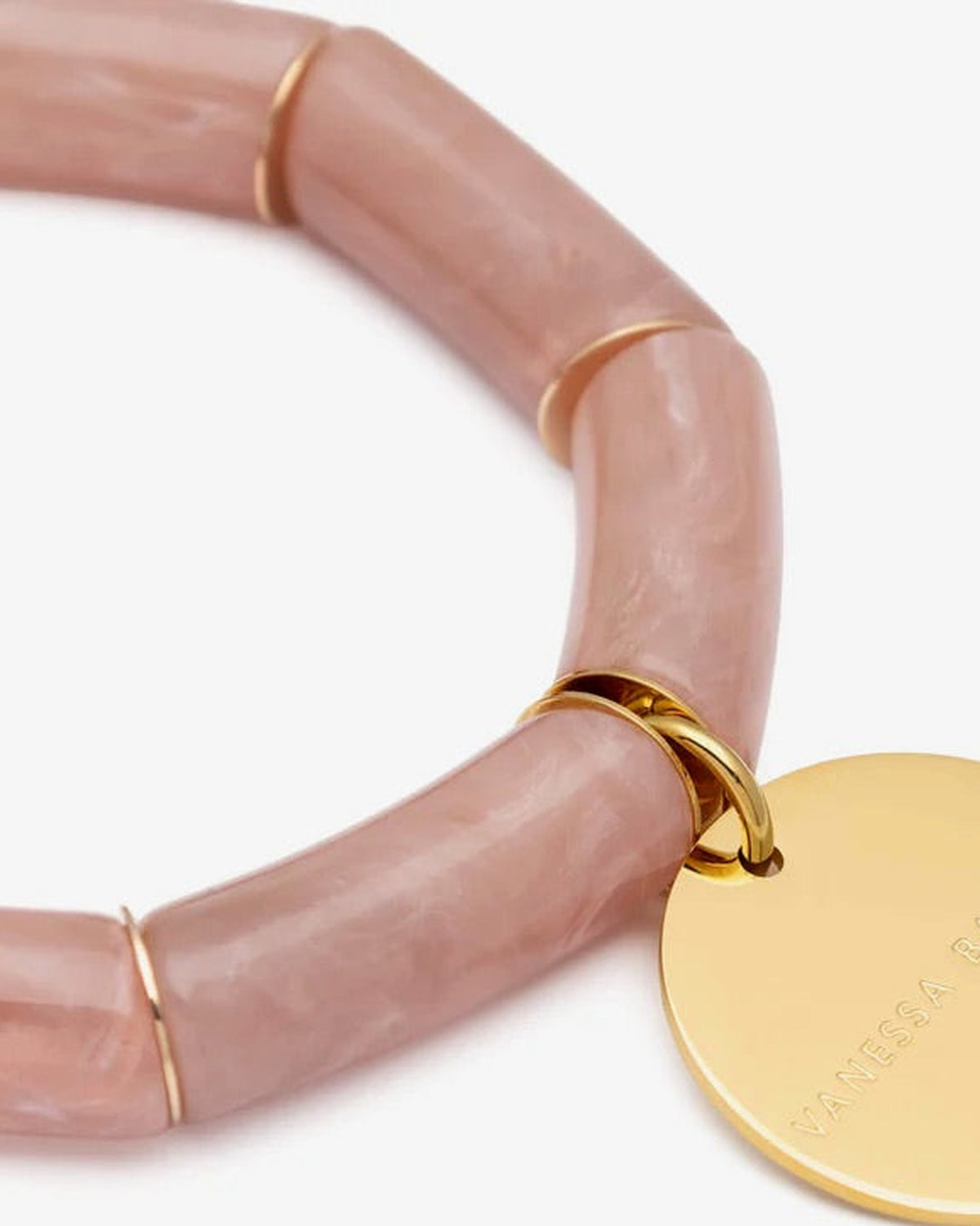 Close-up of the Flex Bracelet Blush Marble by Vanessa Baroni showing the tubular beads with gold discs and the gold logo disc