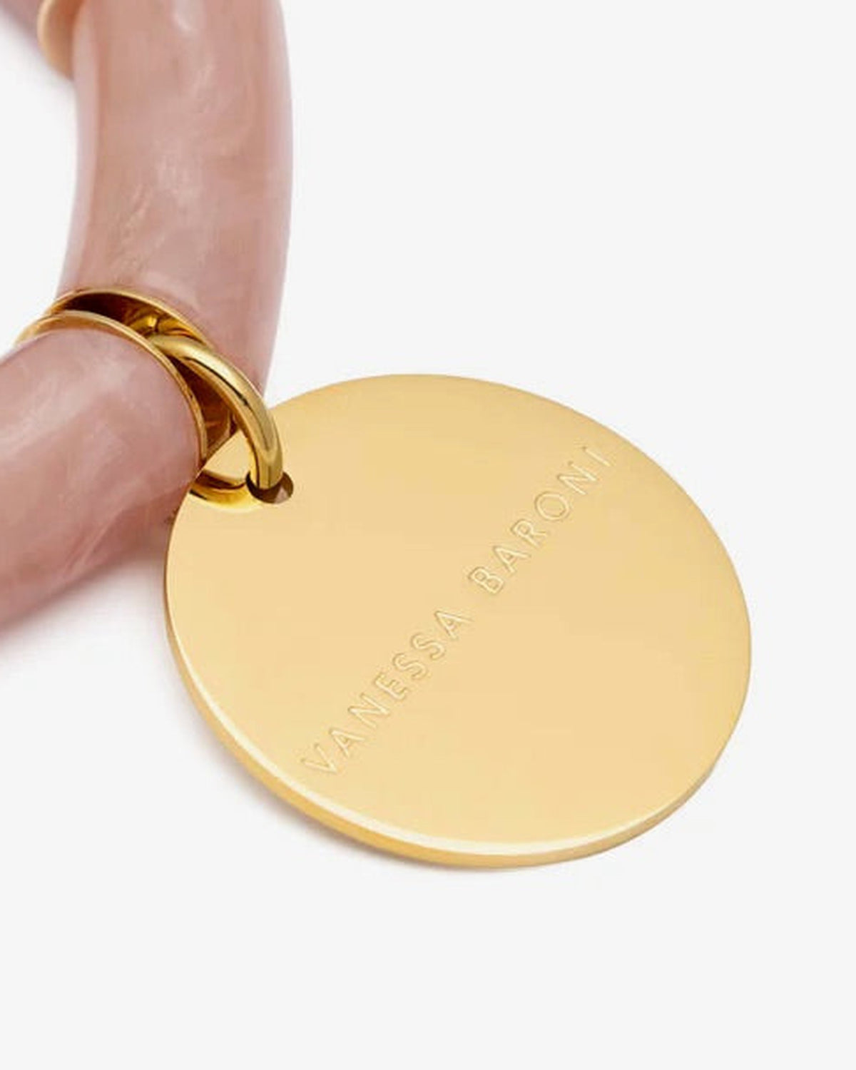 Close-up of the Flex Bracelet Blush Marble by Vanessa Baroni showing the tubular beads with gold discs and the gold logo disc