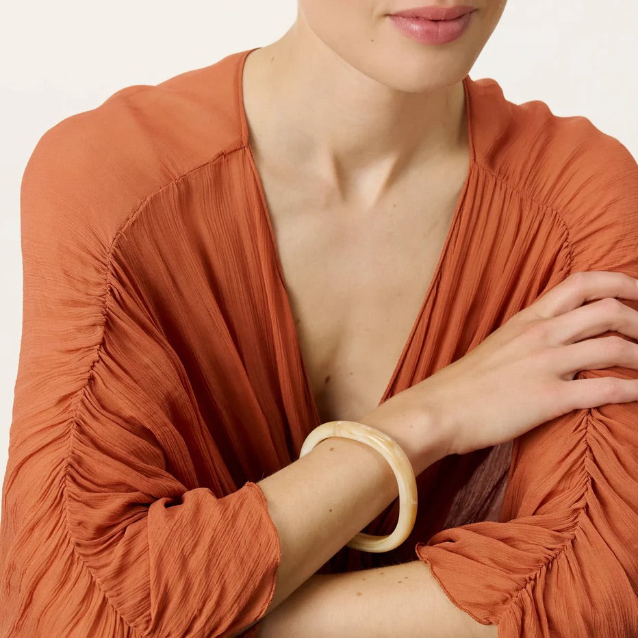 Soft Edge Bangle In Creme Brulee Marble by Vanessa Baroni, worn on a model's wrist