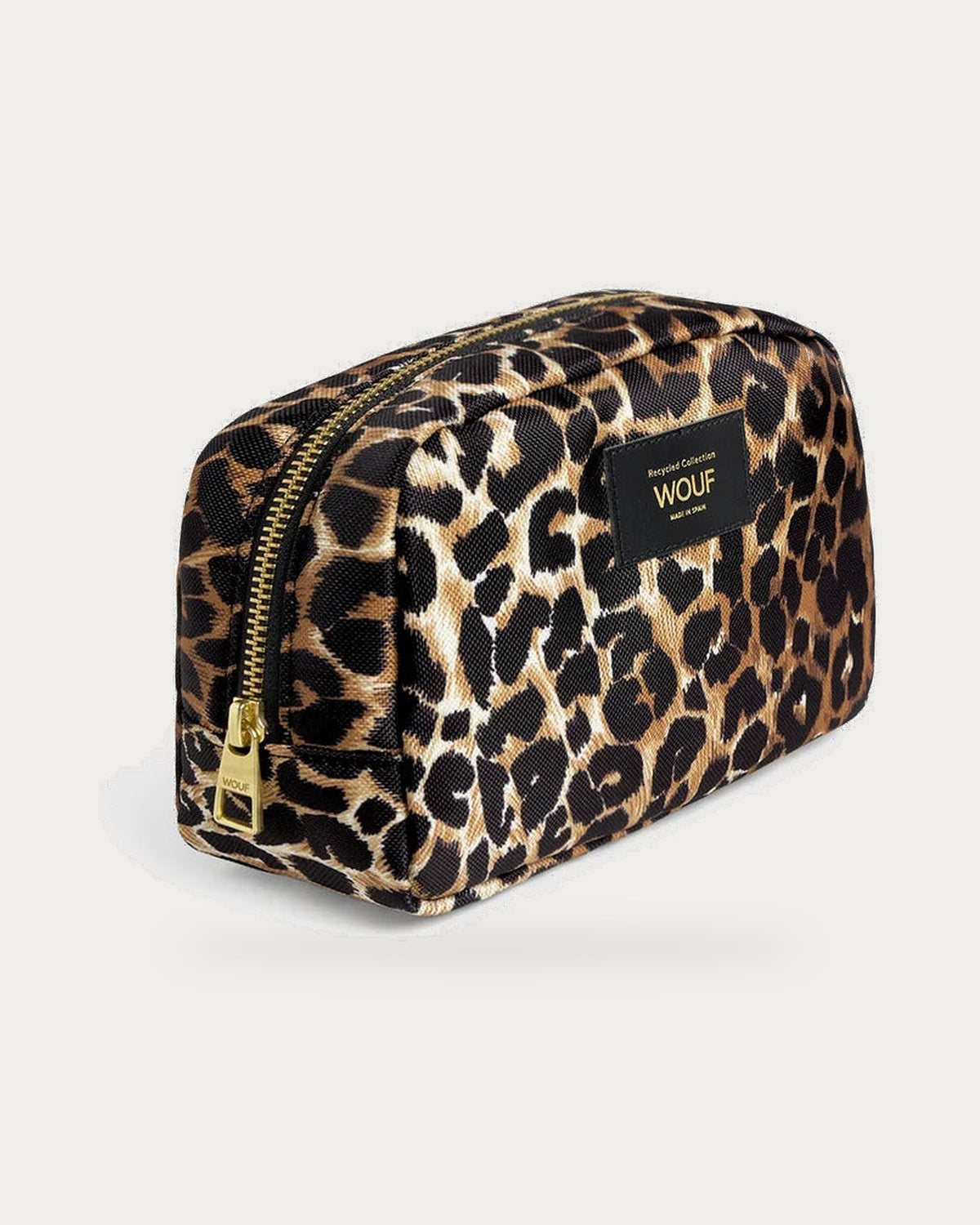 WOUF Icon Toiletry Bag in black and brown leopard print, three-quarter view on soft stone background