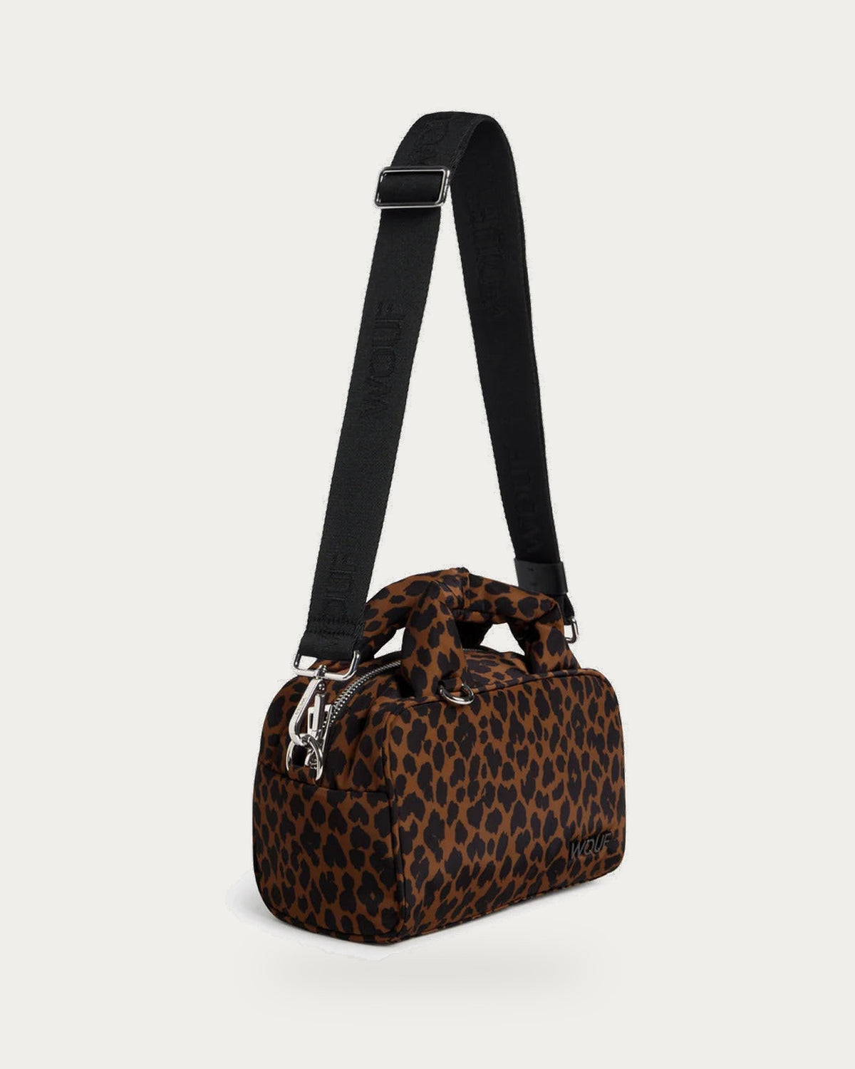 WOUF Leo Bowling Bag in brown and black animal print with crossbody strap, side view on soft stone background