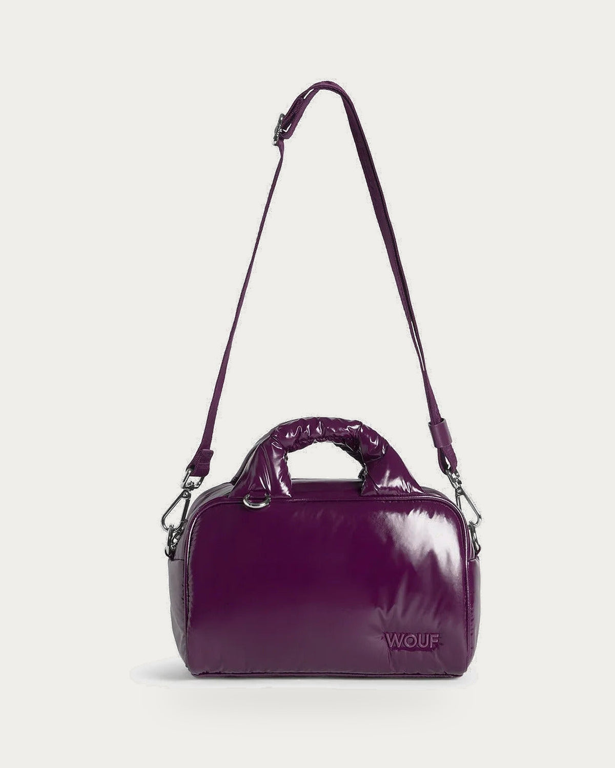 WOUF Plum Bowling Bag in glossy plum recycled nylon with crossbody strap, front view on soft stone background