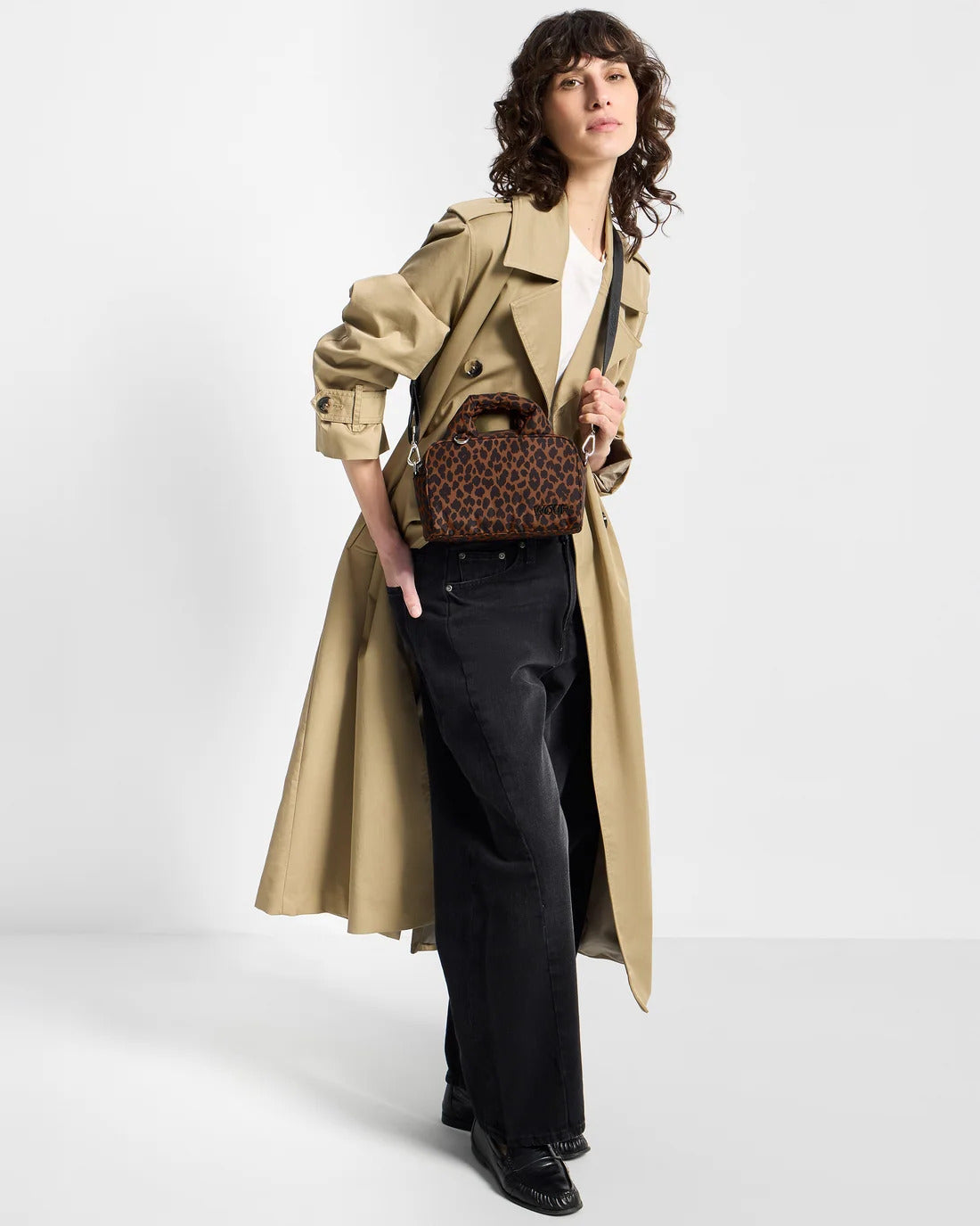 Model full-length carrying the WOUF Leo Bowling Bag in brown and black animal print