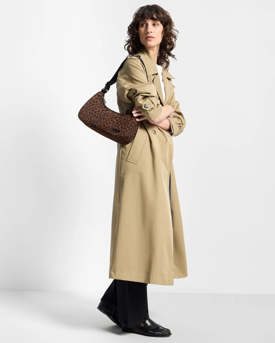 Model wearing the WOUF Leo Crossbody Bag on the shoulder with a beige trench coat