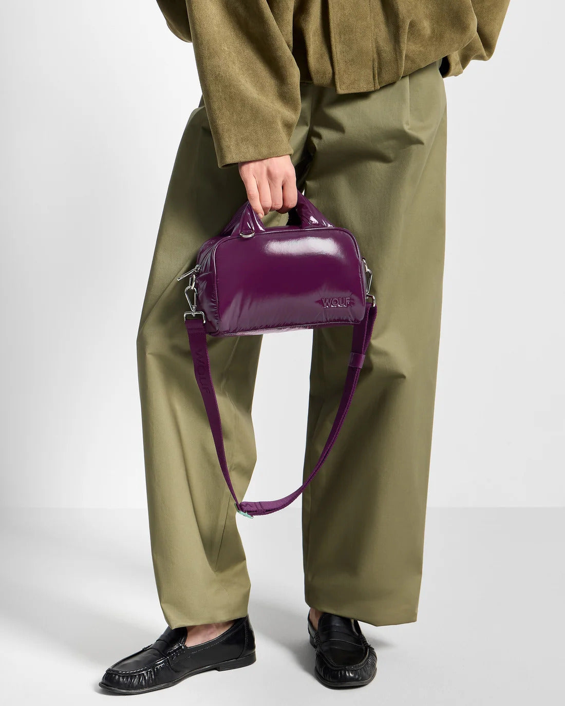 Model holding the WOUF Plum Bowling Bag by its padded handles
