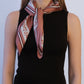 Zodiac Scarf Gemini in Terracotta by Lescarf knotted at the neck and worn with a black sleeveless top